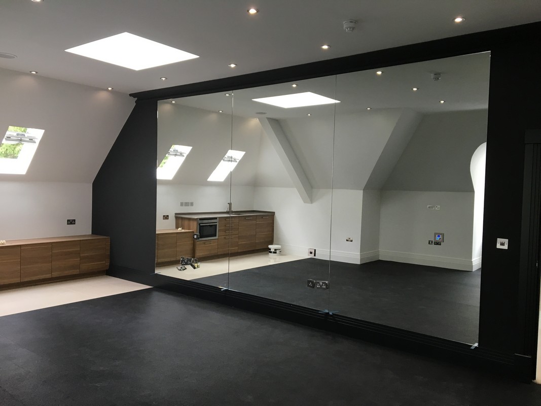 Frameless glass wall dividing loft conversion in Leytonstone